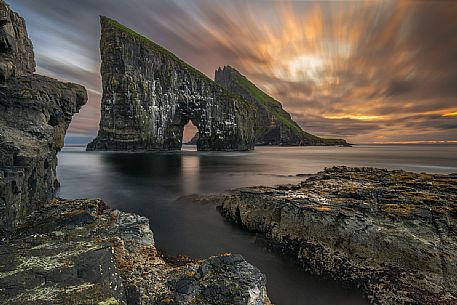 Beautiful sunset on Drangarnir rocks, two sea stacks which are called Stri Drangur (large rock) and Ltli Drangur (small rock) respectively, and are located next to each other between the islands of Vgar and Tindhlmur, Srvgsfjrur Fjord near Srvgur, Faeroe islands, Denmark